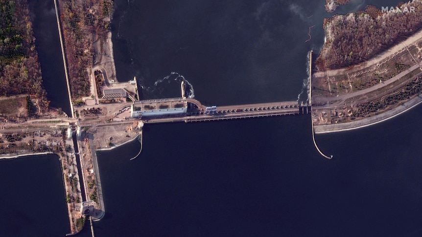 An aerial photograph shows a power plant next to a dam wall