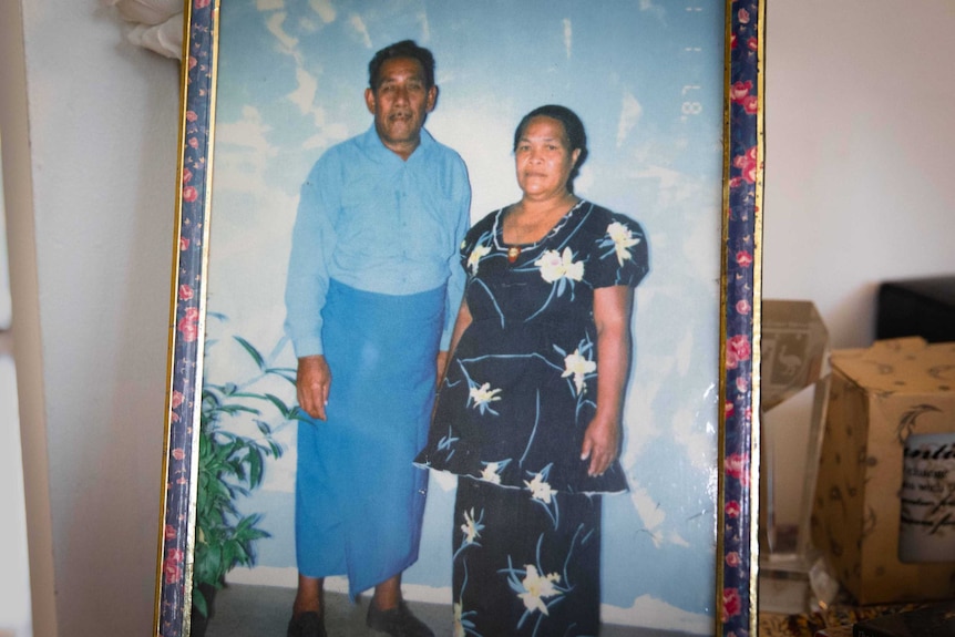 A framed photograph of two middle-aged Samoans in traditional wear.