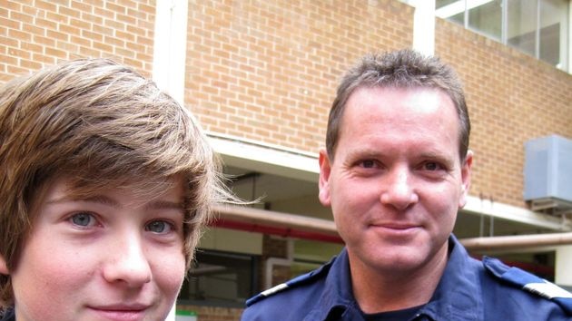 Student Hugh Allen (left) holds a police puppy, with Senior Sergeant Shaun McGovern.