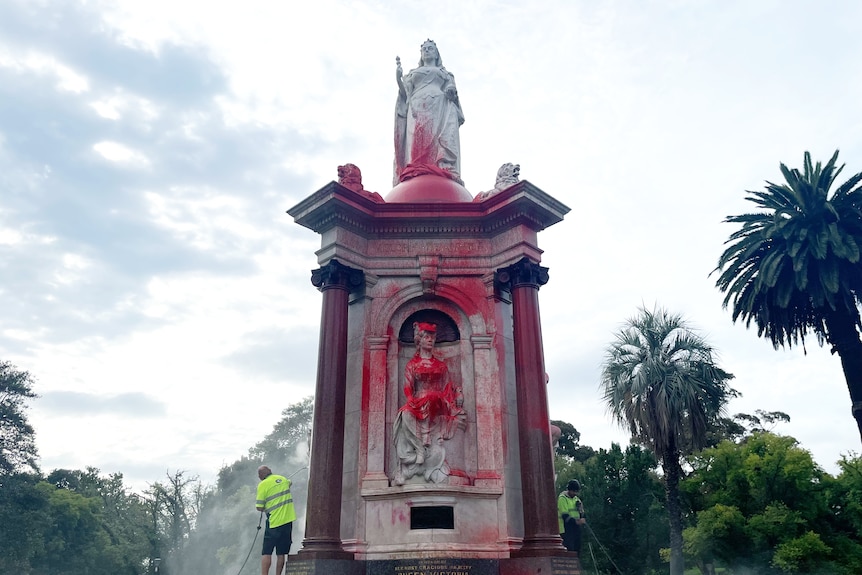 A monument to Queen Victoria covered in red paint.
