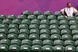 Tennis spectator sits amid empty seats at the 2012 London Olympic Games
