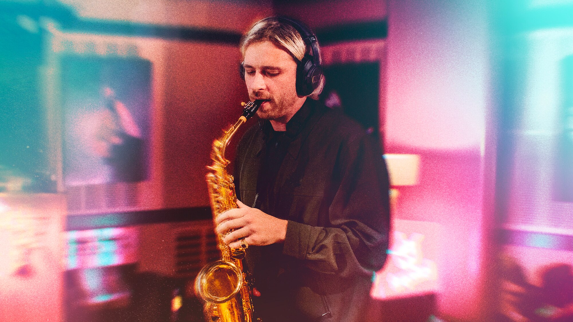Flume playing saxophone in the Like A Version studio with blue and pink filter over the top