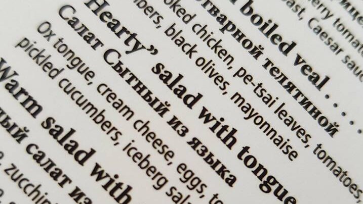 A menu with writing on it highlighting an item called 'hearty' salad with tongue