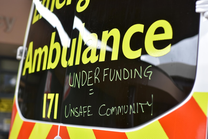 An ambulance with words drawn on its windows