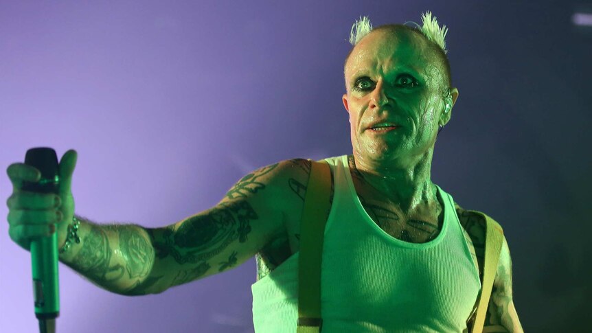 Keith Flint stares into space, his singlet drenched in sweat, as he performs with The Prodigy