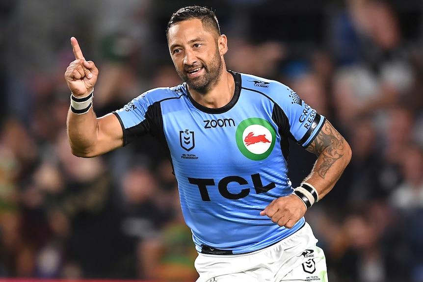 A South Sydney NRL player points a finger on his right hand as he celebrates a try against the Gold Coast Titans.