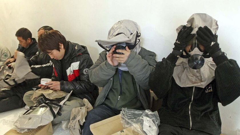 Residents put on gas masks in an air raid bunker