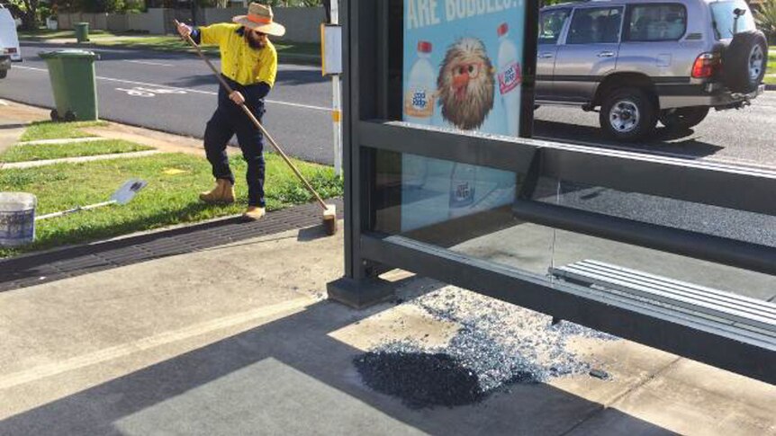 Glass being cleaned up from one of the 65 bus shelters that has been destroyed in Redcliffe.