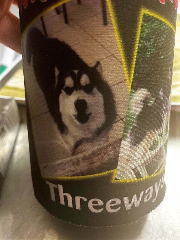 A close-up of a stubby cooler from Threeways Roadhouse NT featuring the face of a husky dog