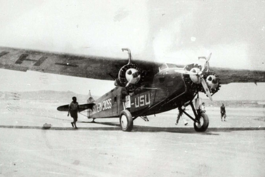 A light plane rests on Seven Mile Beach