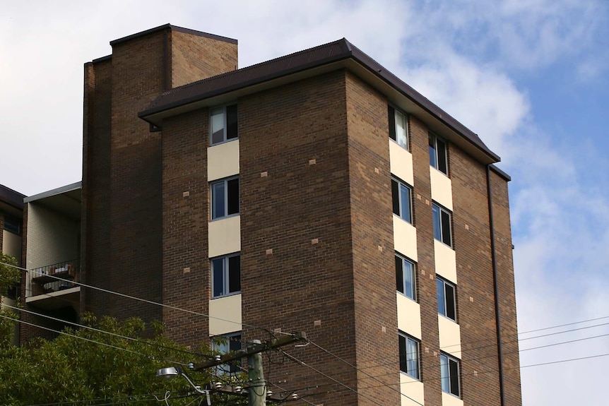 A long shot of the top floors of an older-style brick apartment block.