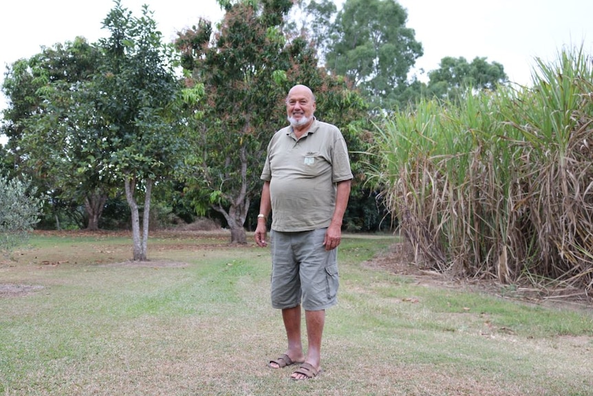 Wide photo of Adbul Ghani Mohammed standing in front of his cane paddock.