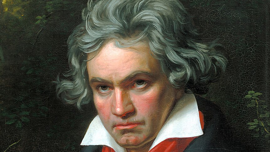 A painting of Beethoven with grey hair, a white shirt, black jacket and red scarf. He is looking stern.