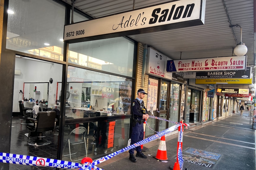 Police tape and police officer outside hair salon