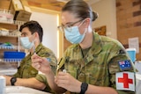 Two Australian Defence Force nurses, both wearing masks.