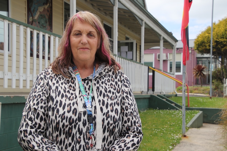 A woman standing in front of a house.