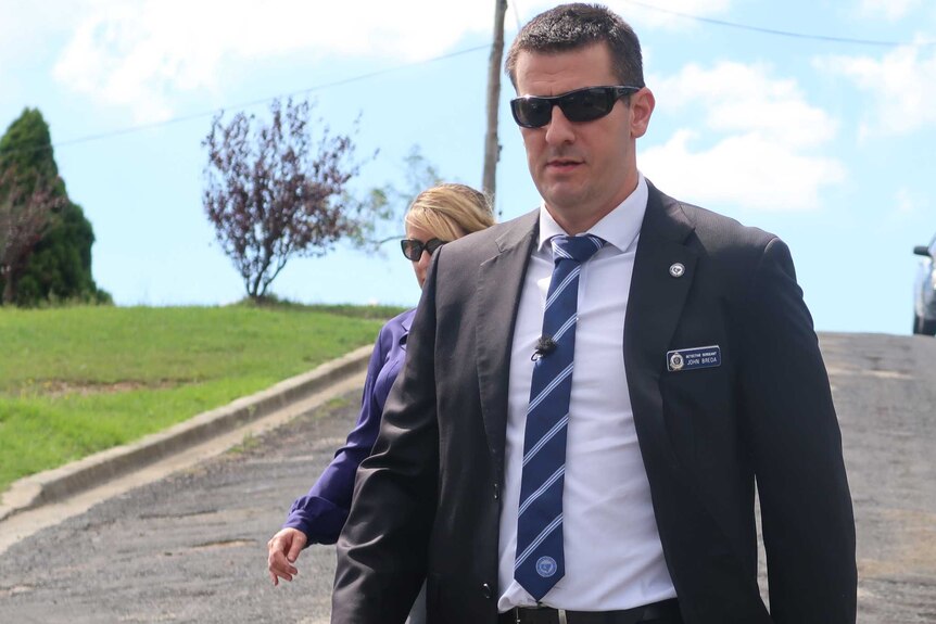 Detective Sergeant John Breda walks down a street at the scene of the arrest of alleged child abuser.