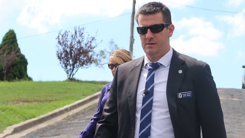 Detective Sergeant John Breda walks down a street at the scene of the arrest of alleged child abuser.