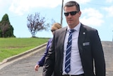 Detective Sergeant John Breda walks down a street at the scene of the arrest of alleged child abuser.
