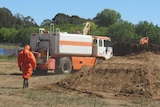 Asbestos removalists have begun taking away contaminated soil piles from the development site in Campbell.
