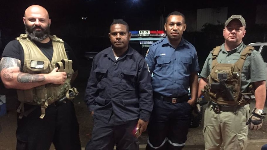 Two men from US organisation, Laurence Aviation and Security Group, pose with PNG police.
