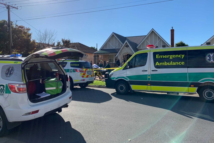 An ambulance and emergency service vehicles outside a home.