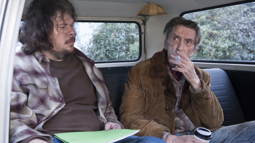 Harry Dean Stanton smokes in the back of a car in a scene from Twin Peaks.