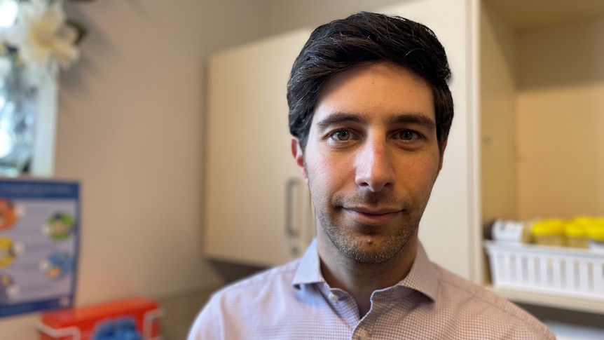 Doctor in his office, wearing a business shirt.