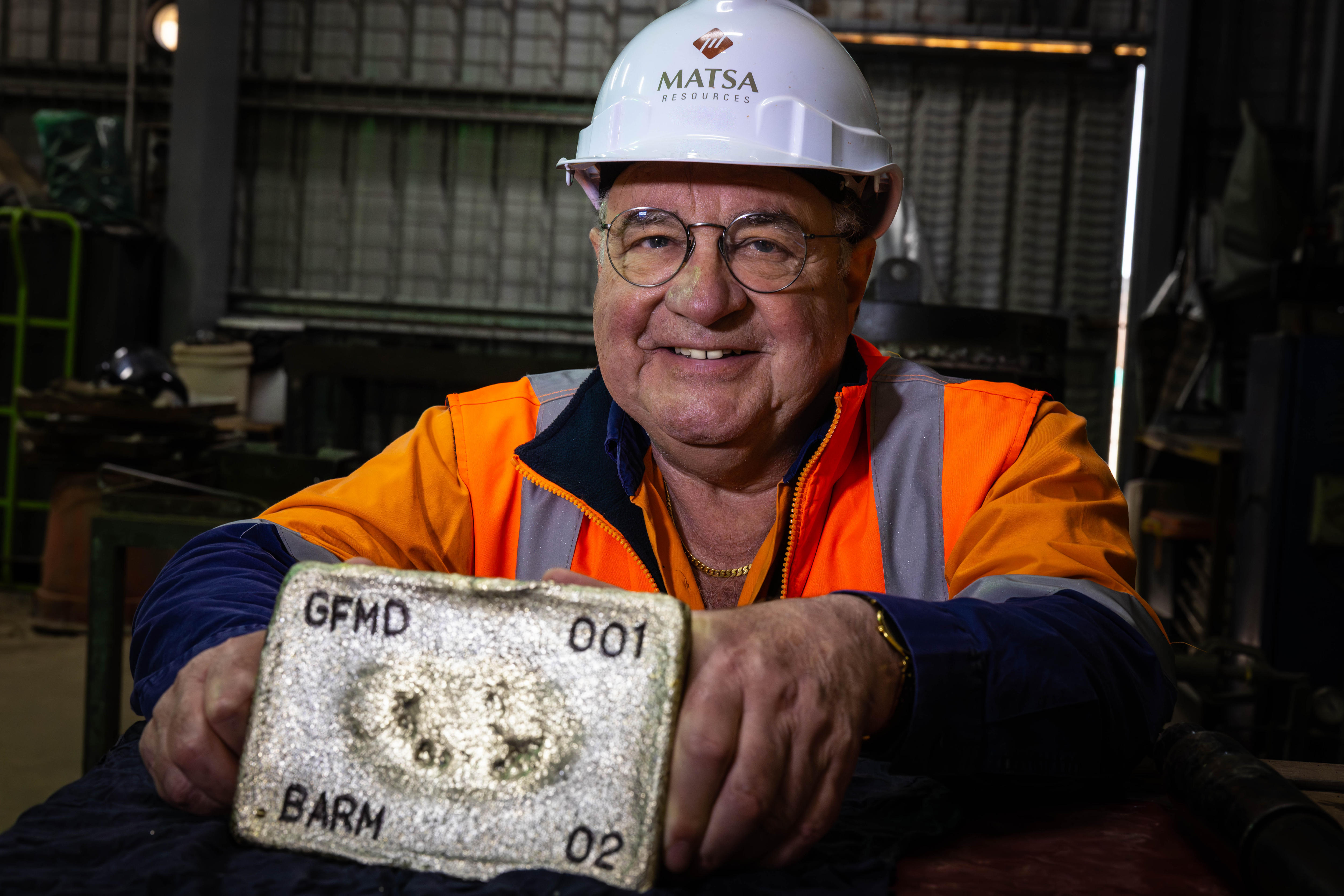 A mining executive holding a gold bar.  