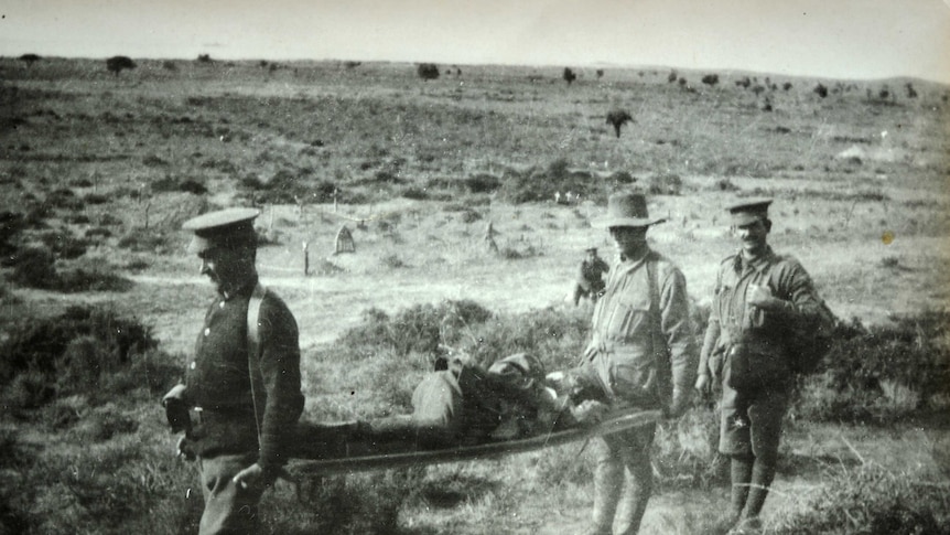 Two men carrying injured soldier on stretcher with third man at Suvla World War 1