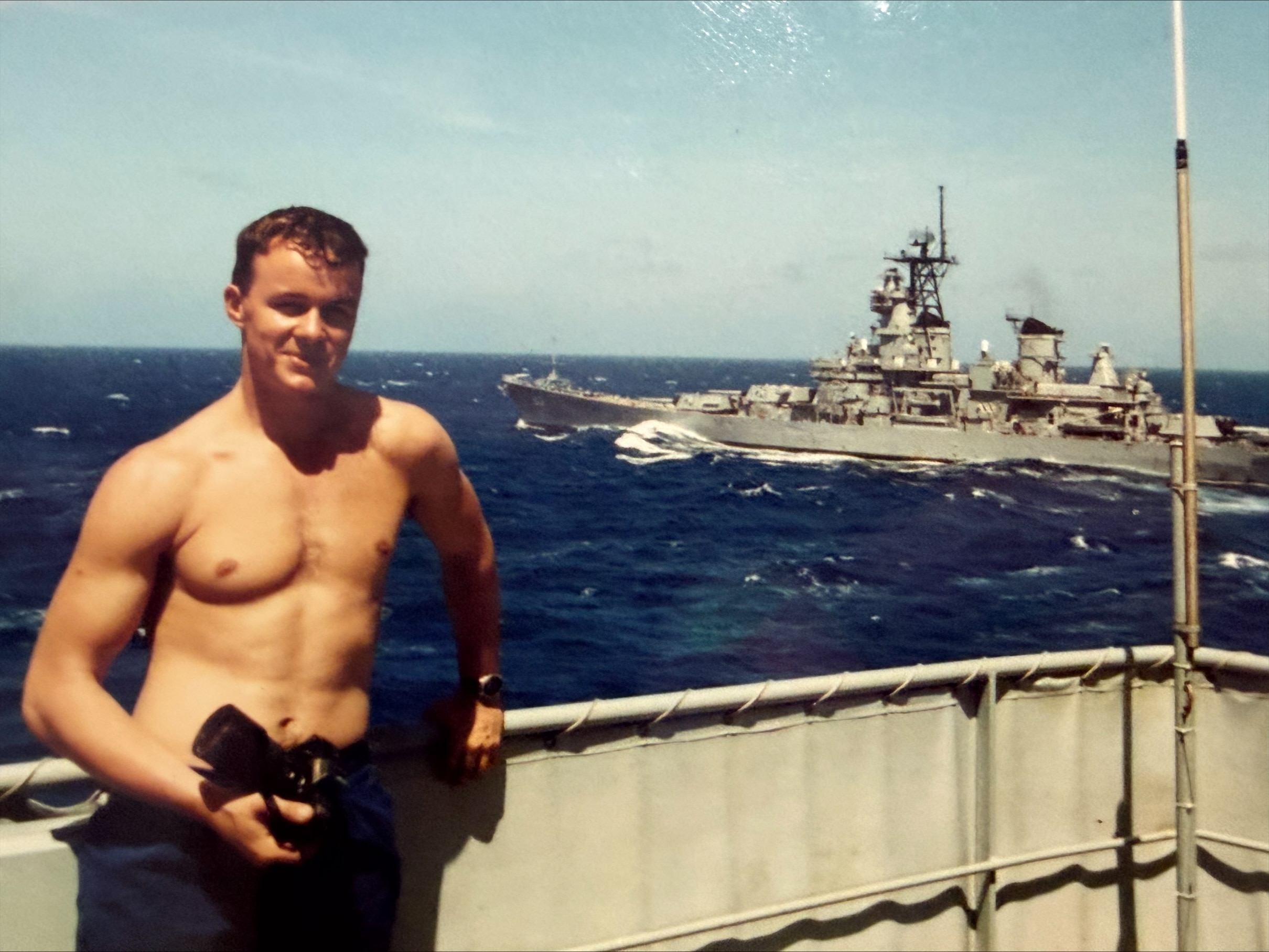 Мужчина без рубашки на военном корабле.