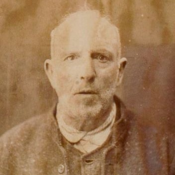 An aged, sepia-toned image of a John Conder, a man with grey hair and stubble looking straight ahead.