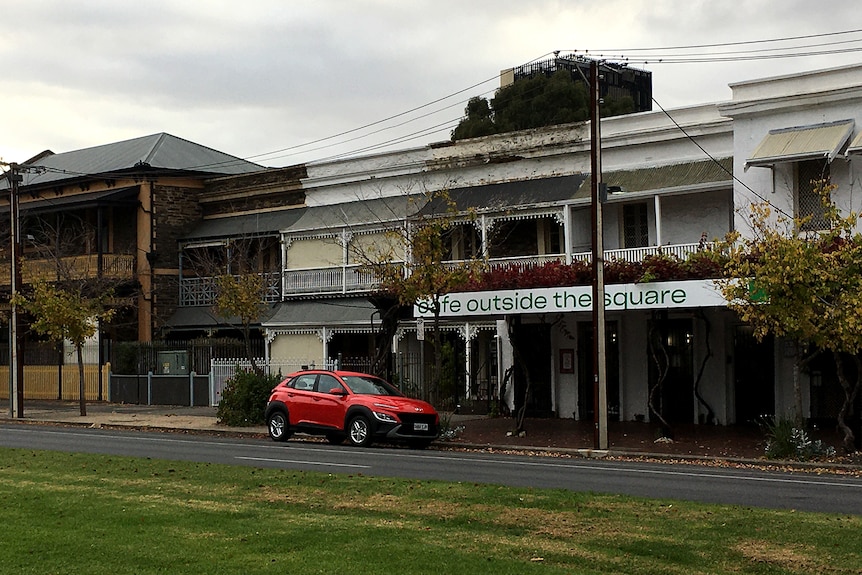 A row of houses adjacent a city square.