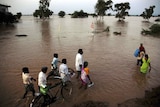 Family wade through floodwaters in southern India