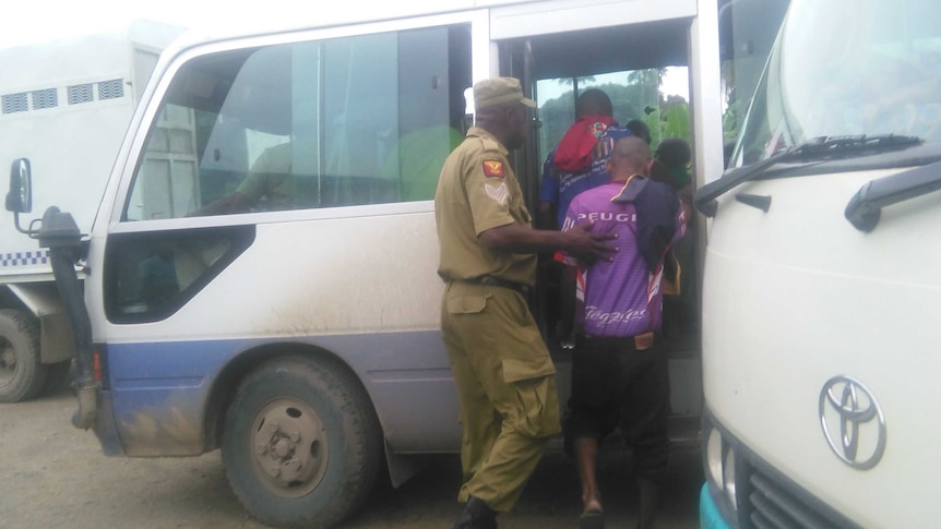 Correctional Service officers escorting some of the 99 accused onto a bus to take them to remand,  23 March 2017