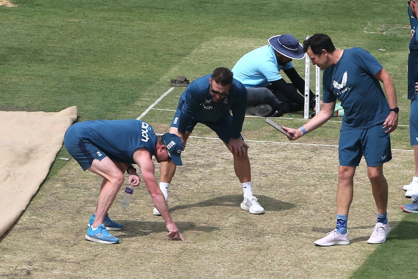 England cricket coach Brendon McCullum and support staff look and point at the pitch in Ranchi before a Test against India.