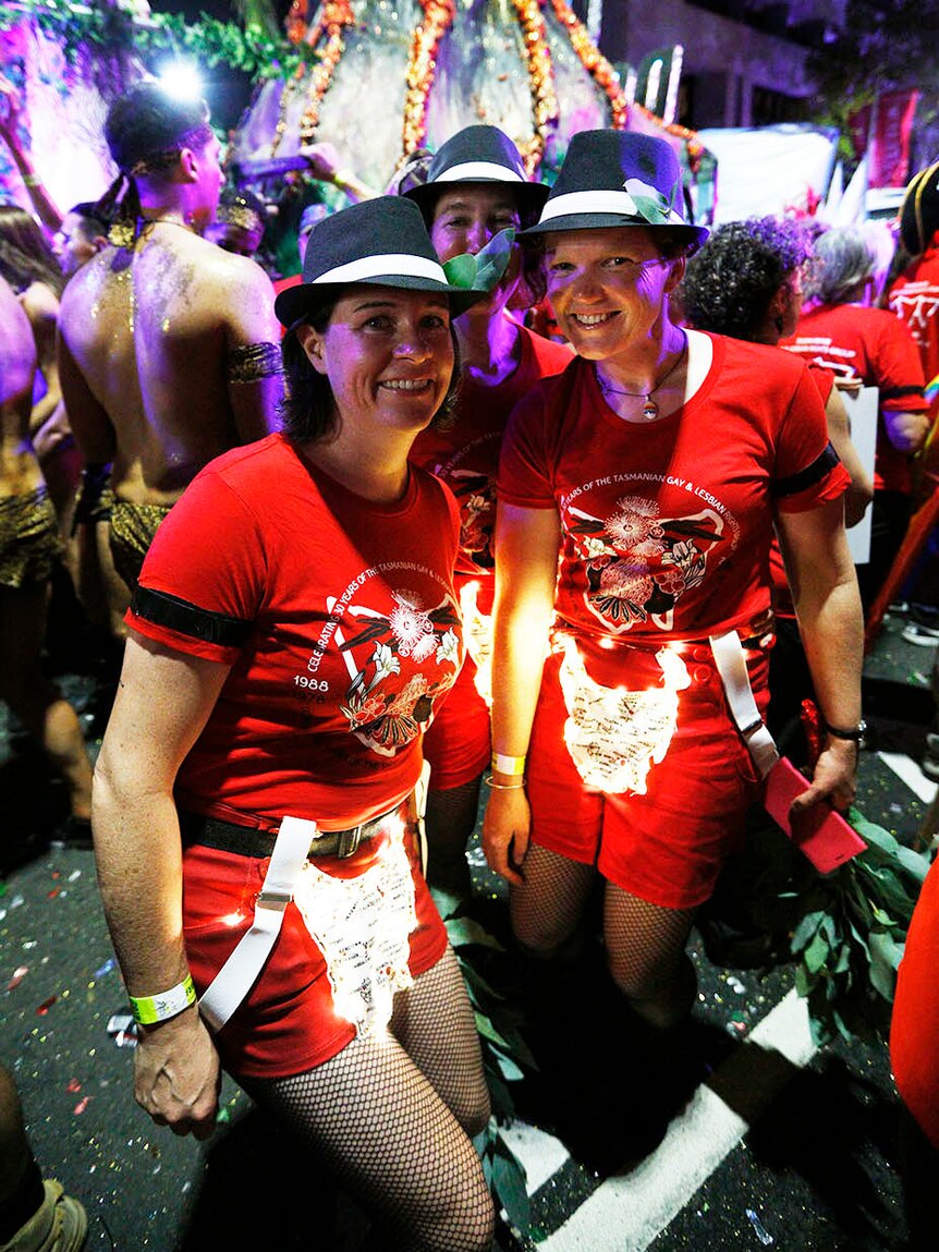 Two women at Mardi Gras wear black armbands
