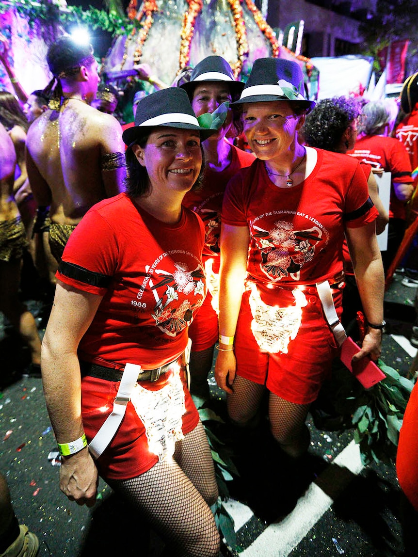 Two women at Mardi Gras wear black armbands