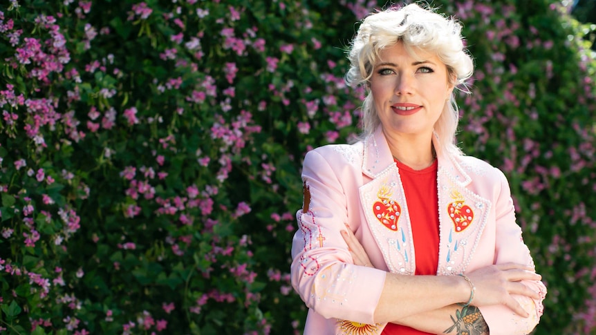 Portrait of Clementine Ford staring into camera in a garden.