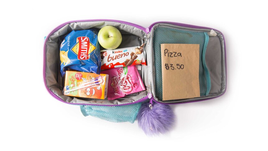 A pizza lunch order, potato chips, chocolate bar, lollies, an apple and orange fruit box in a purple cooler bag.