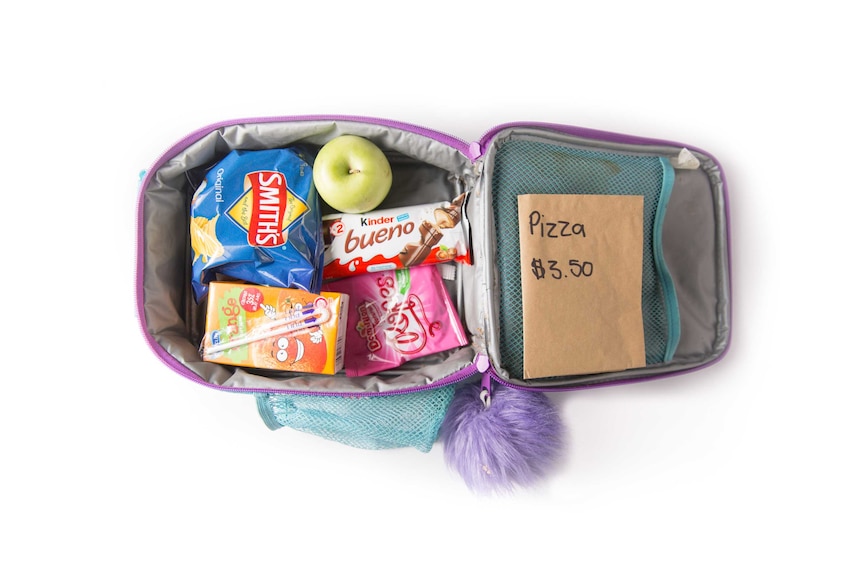 A pizza lunch order, potato chips, chocolate bar, lollies, an apple and orange fruit box in a purple cooler bag.