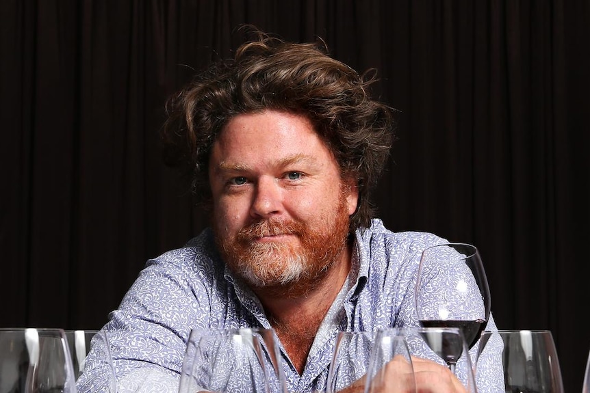 Wine writer, Nick Ryan poses with glasses of wine. 