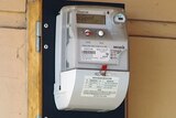A smart meter electricity reader installed on a weatherboard home.