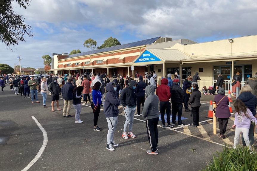 A long queue of dozens and dozens of people queuing outside a hall in Epping.