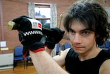 A young man holds a sword over his shoulder