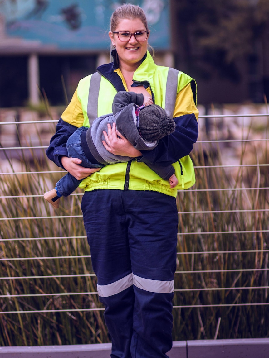 Karina Hampton breast-feeding baby in high-vis workwear. 