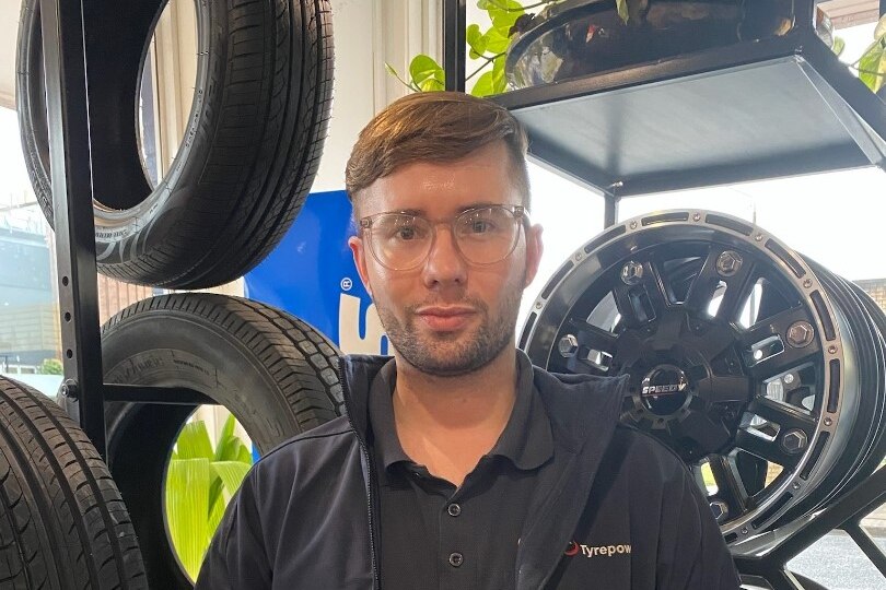 Man stands in a tyre repair shop. 