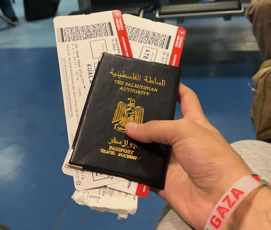 A hand holding a Palestinian passport. 