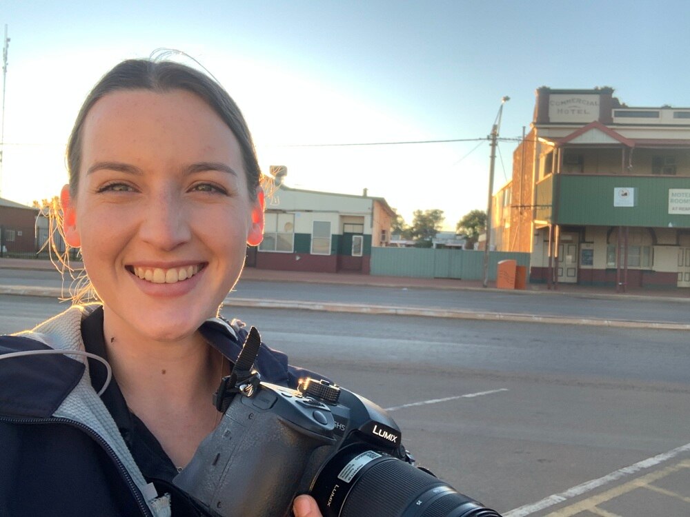 A young woman with a camera around here neck.