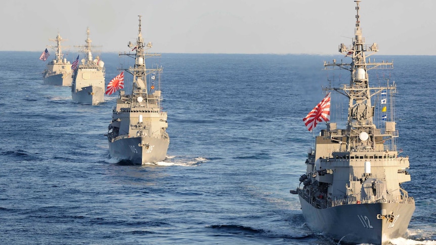 Military ships with the US dan Japan flags in the ocean